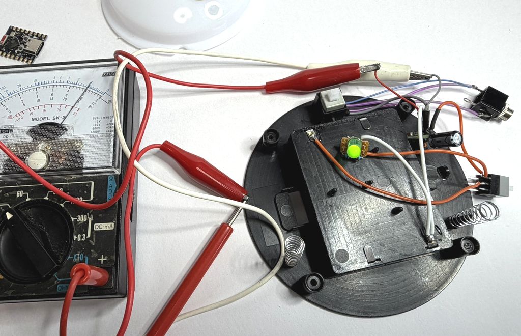 テスターでDC-DC昇圧基板の出力電圧を確認している状態