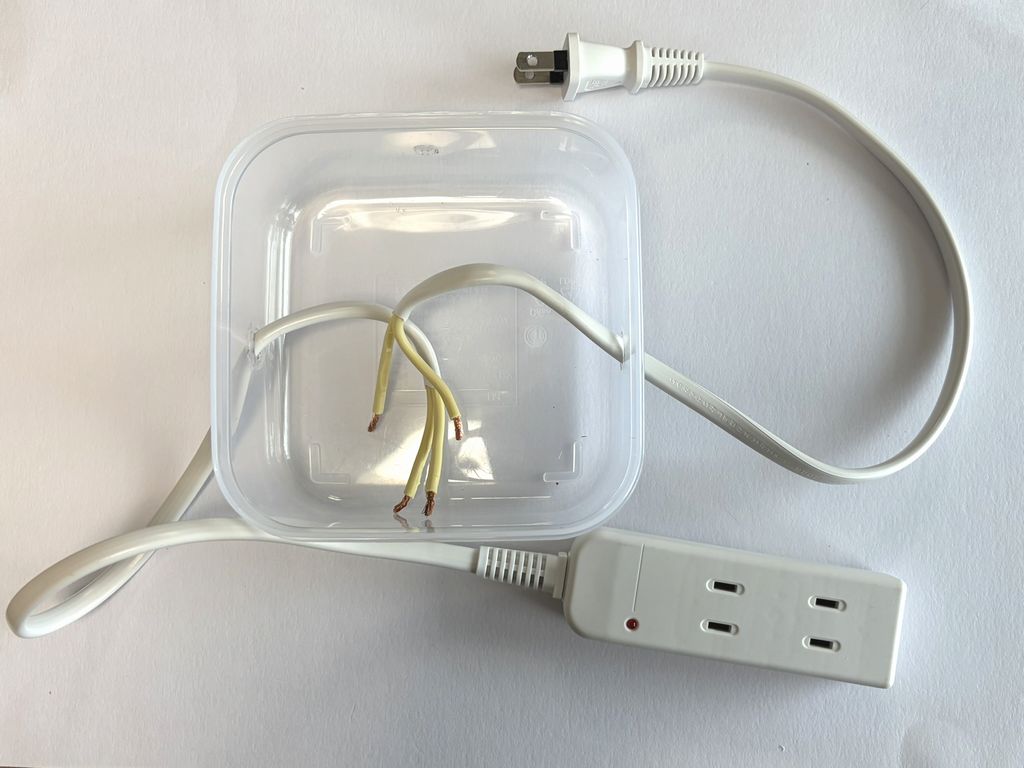 電源タップを切断してケースに通した状態